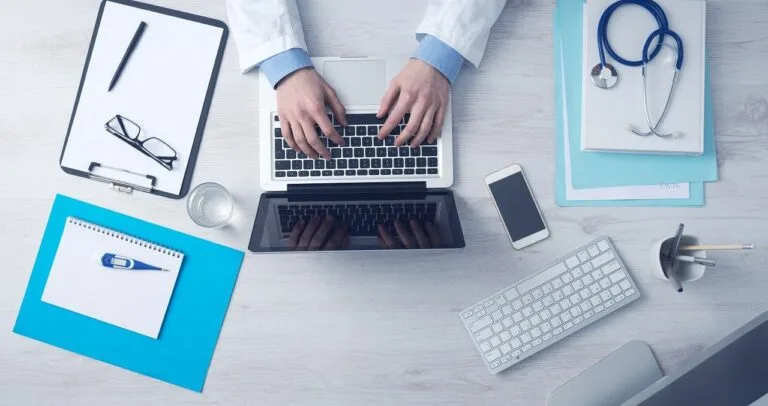 A Medical Practioner is using laptop concerning How to Start a New Medical Billing Business