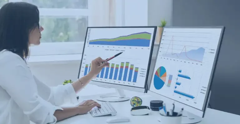 Top-5-Credentialing-Issues-In-Healthcare-You-Must-Know A woman focused on her computer work, using two monitors to enhance her productivity in a modern office setting reade about top 5 Credentialing Issues In Healthcare.